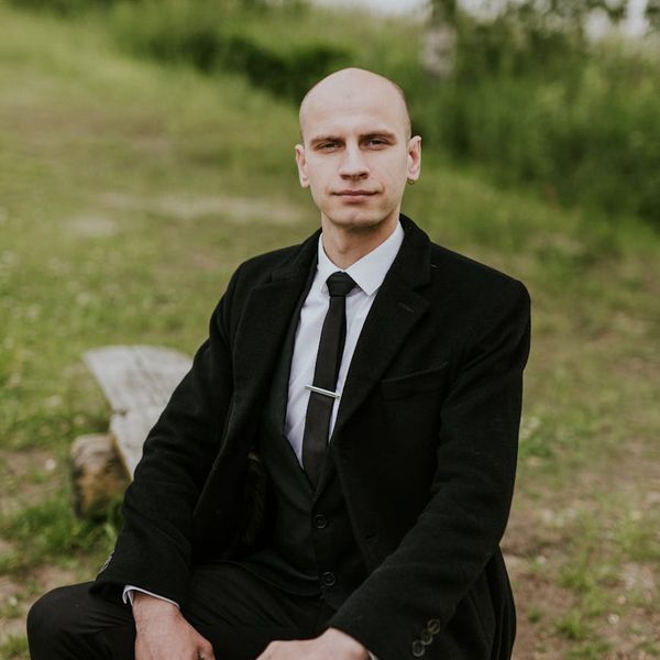 A person sitting calmly, looking peaceful and centered in a natural environment.